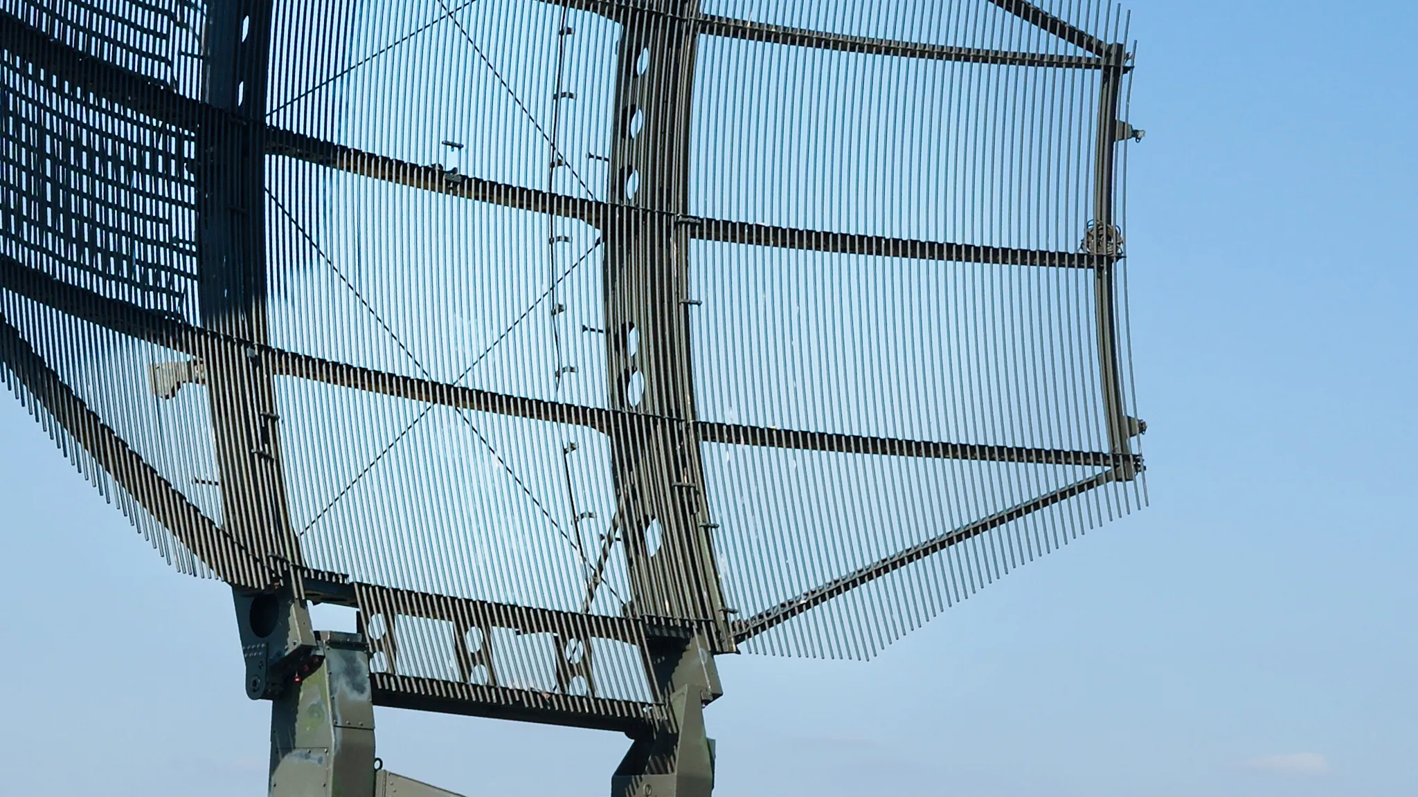 MILITARY ANTENNA/SIGNAL DISH IN FRONT OF A BLUE SKY.