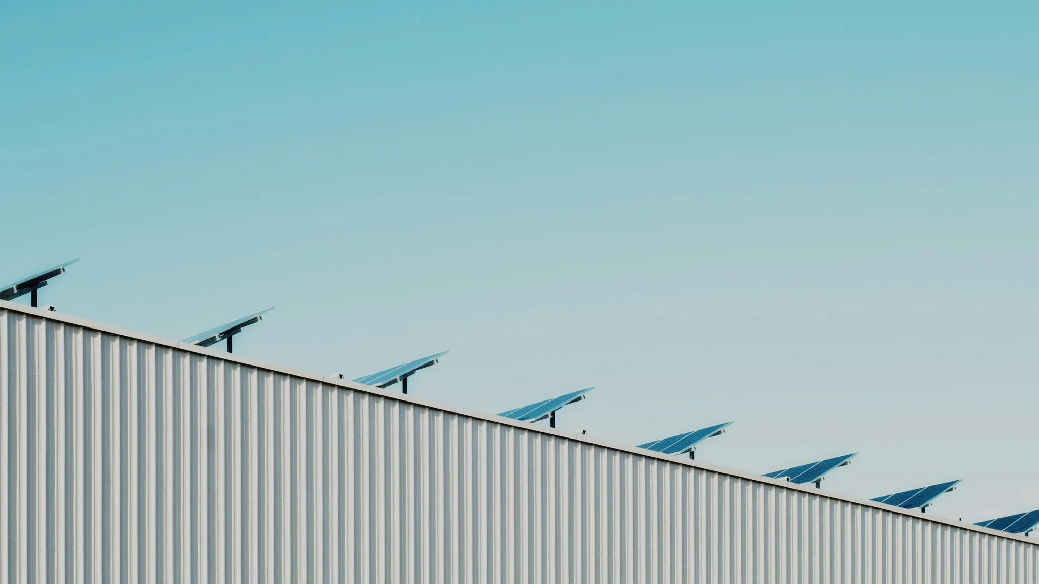 Hallendach mit Solarpaneelen unter blauem Himmel